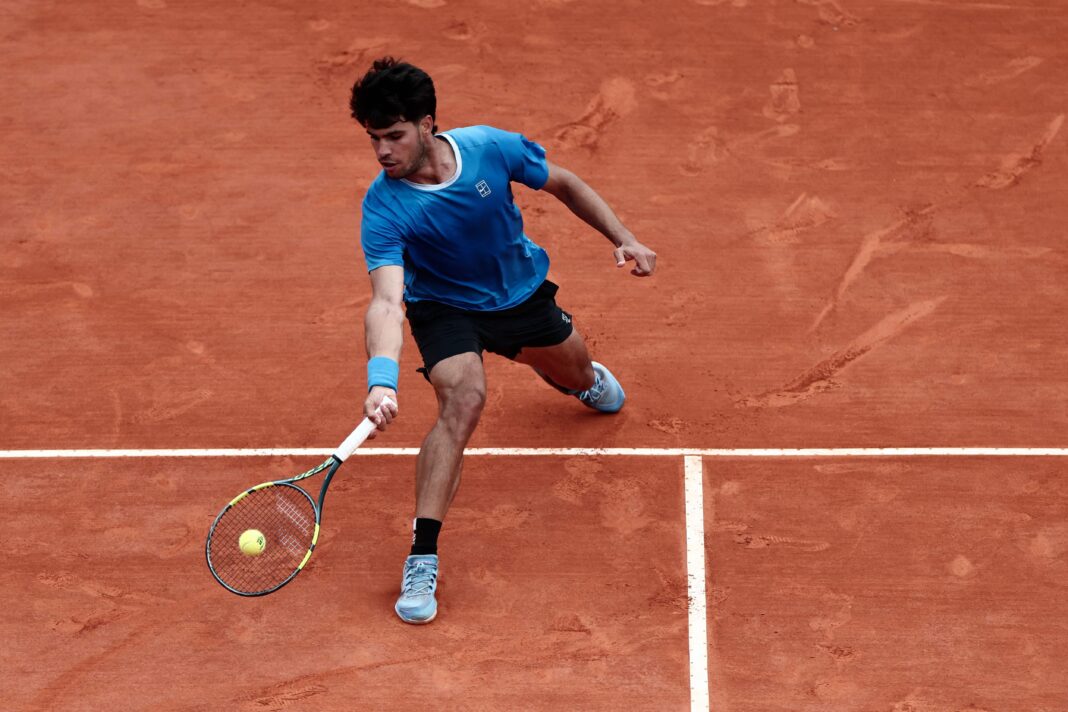 Carlos Alcaraz y Jannik Sinner en la cancha durante un partido de tenis.