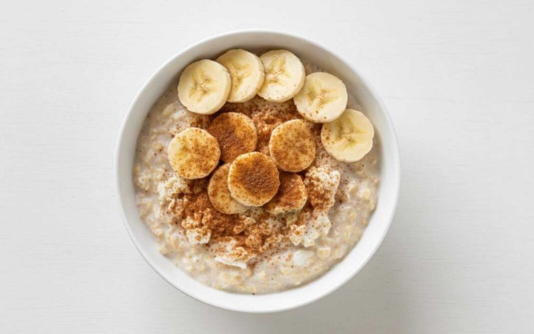 Bowl con avena cocida, trozos de banana y un toque de canela, listo para consumir después del ejercicio.