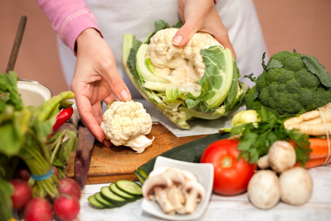 Ilustración de un plato con verduras variadas y un cerebro, representando la conexión entre dieta vegetal y salud cognitiva.