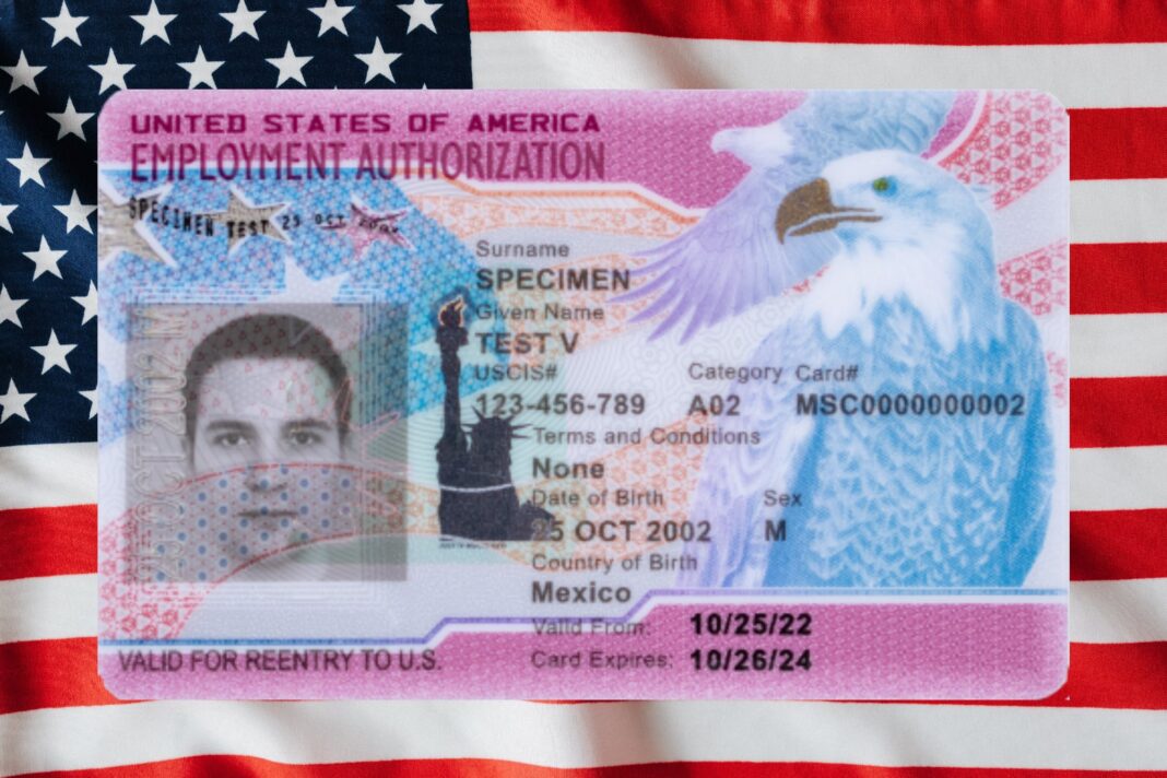 Documentos de inmigración y permiso de trabajo de Estados Unidos sobre una mesa.