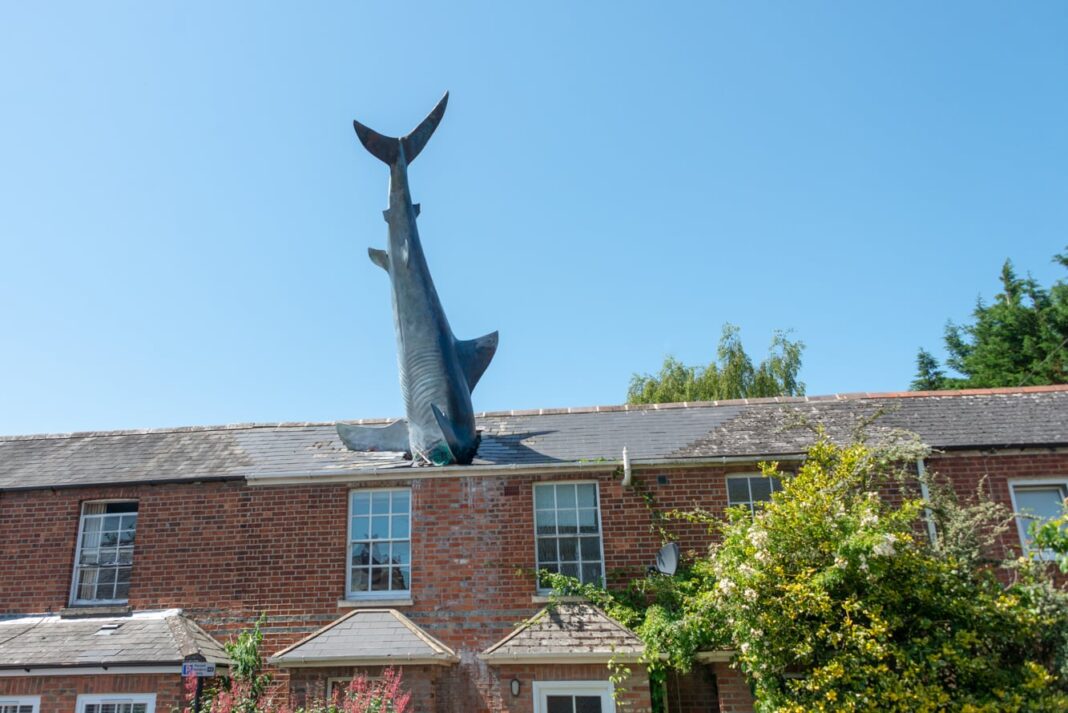 Fotografía de la casa 'Headington Shark House' en Oxford, con una gran escultura de un tiburón incrustada en el techo.