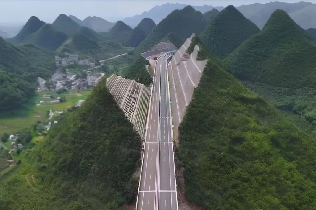 Vista aérea de una montaña partida al medio con una autopista de cuatro carriles en construcción en Guizhou, China