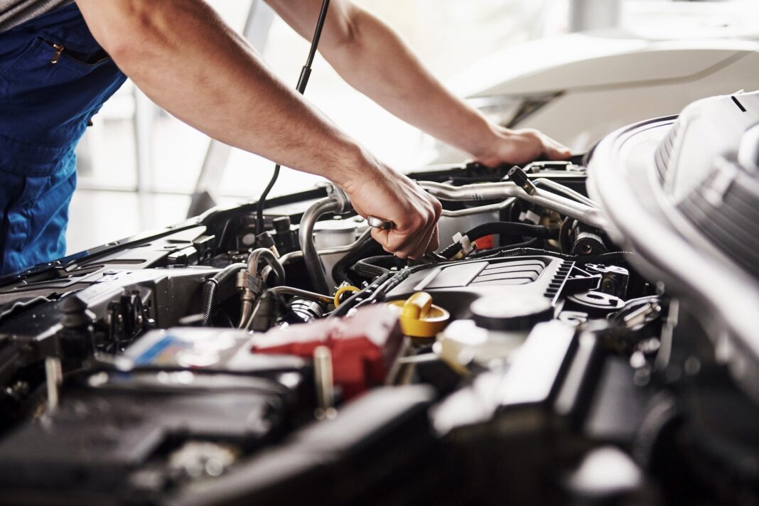 Mecánico trabajando en un automóvil dentro de un taller en Argentina