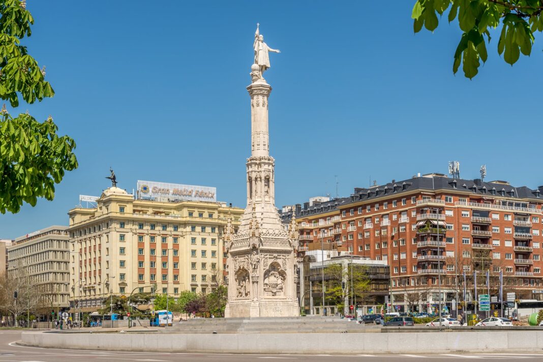 Contraste entre un edificio de lujo en una ciudad española y una casa tradicional en un pueblo rural.