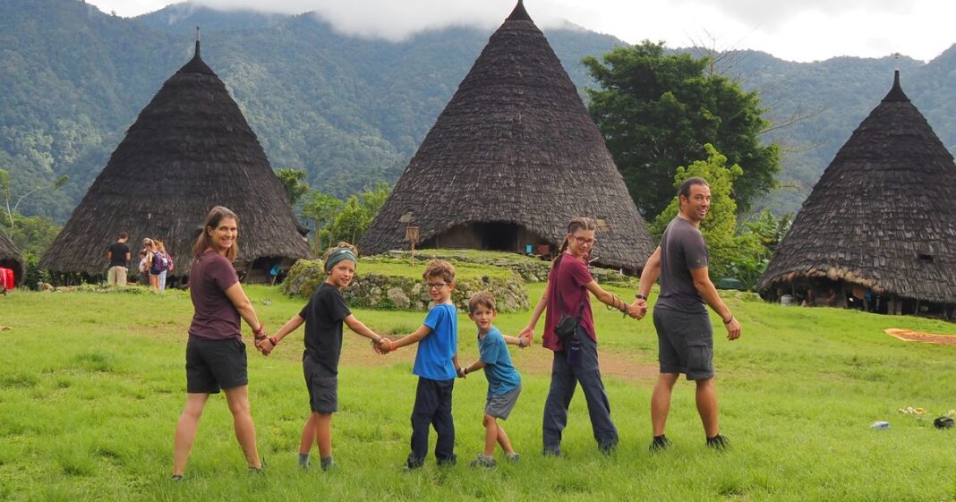 Familia Pelletier Lemay sonriendo durante su viaje por el mundo, con un paisaje de fondo.