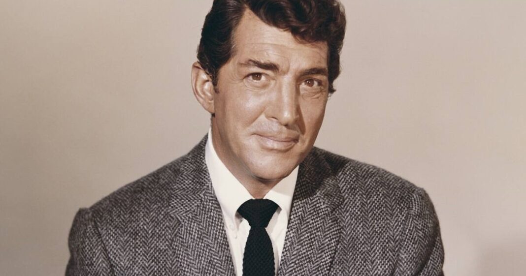 Dean Martin sonriendo con su característico estilo relajado.