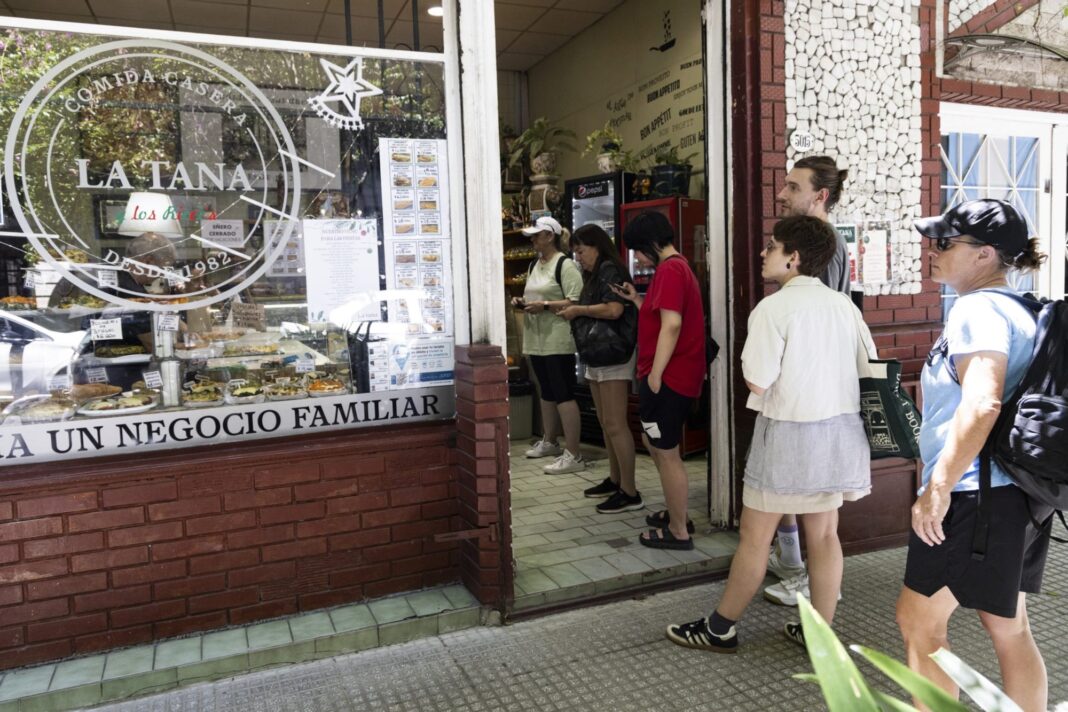 Fachada de la rotisería La Tana en Palermo, con mostrador y clientes.
