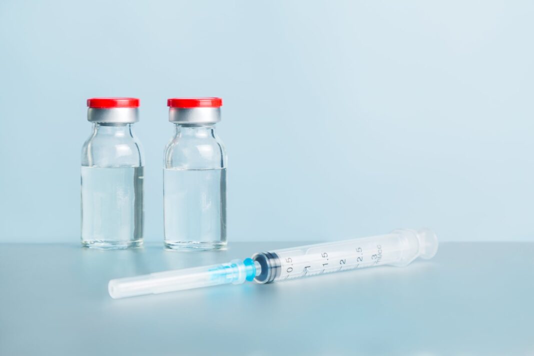 Ilustración de un frasco de medicamento con un lazo de color naranja, símbolo de la lucha contra el cáncer.