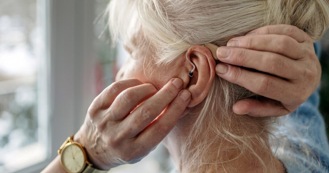 Persona mayor usando audífonos, cuidando su salud auditiva y cognitiva