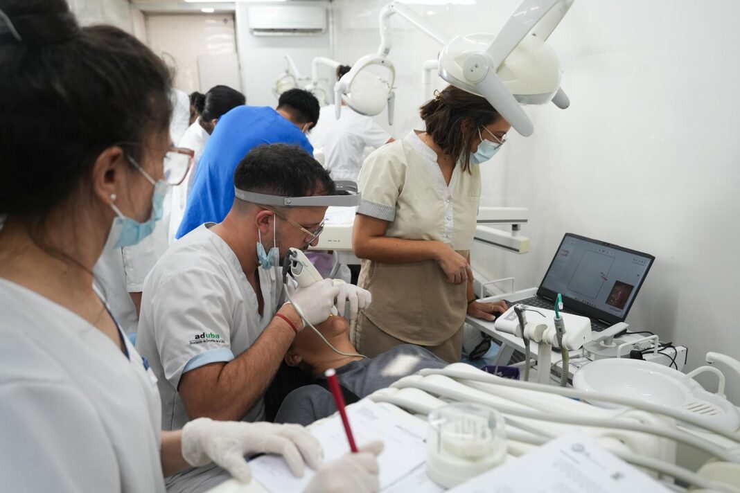 Fila de personas esperando frente a camiones de salud de la UBA en la Avenida Córdoba, durante la jornada de protesta por financiamiento.