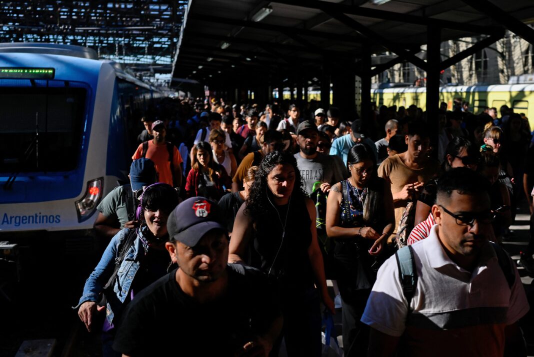 Tren en estación con pasajeros esperando