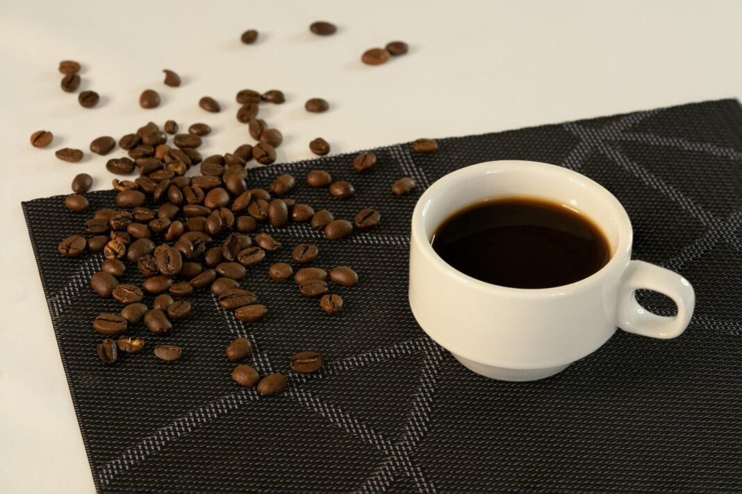 Taza de café espresso junto a granos de café