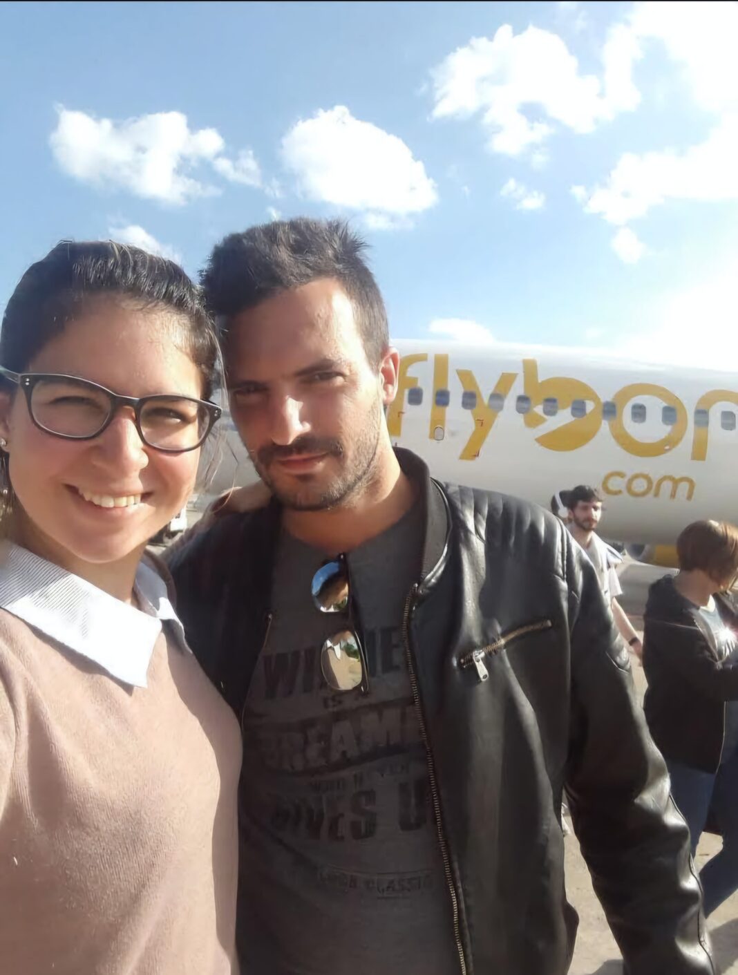 Pareja abrazada sobre una moto, sonriendo