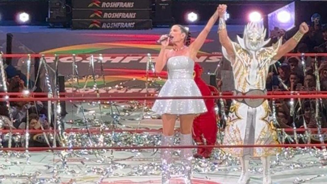Místico y Natalia Jiménez abrazándose en el ring de la Arena México durante la interpretación de Me Muero