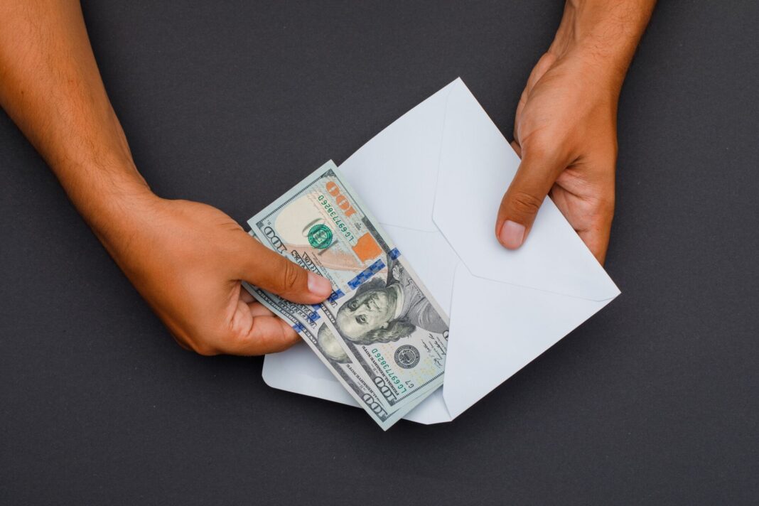 Documentos y dinero sobre una mesa, representando trámites migratorios