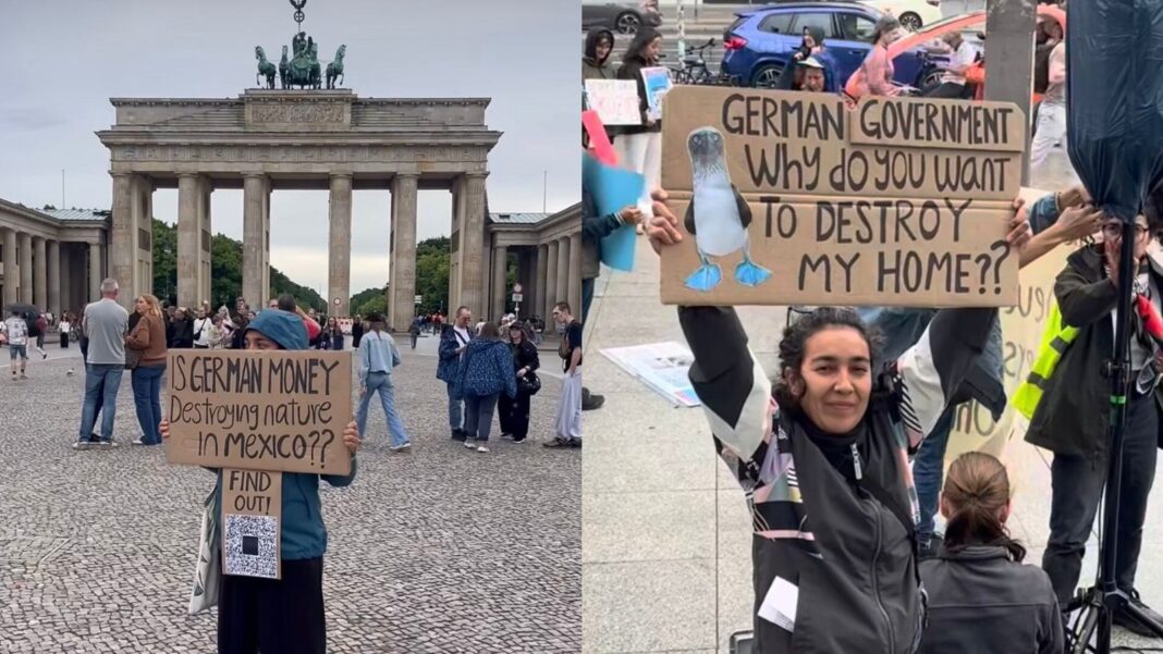 Bióloga mexicana sostiene cartel en la Puerta de Brandeburgo durante protesta contra planta de amoniaco