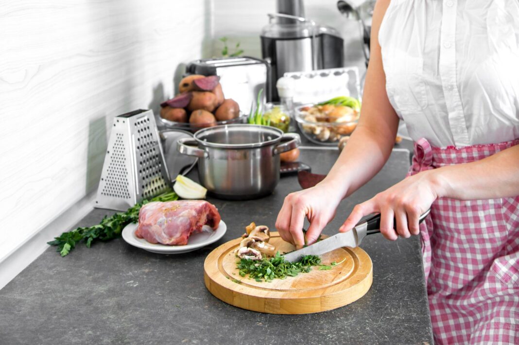 Cocinera en una cocina doméstica preparando alimentos