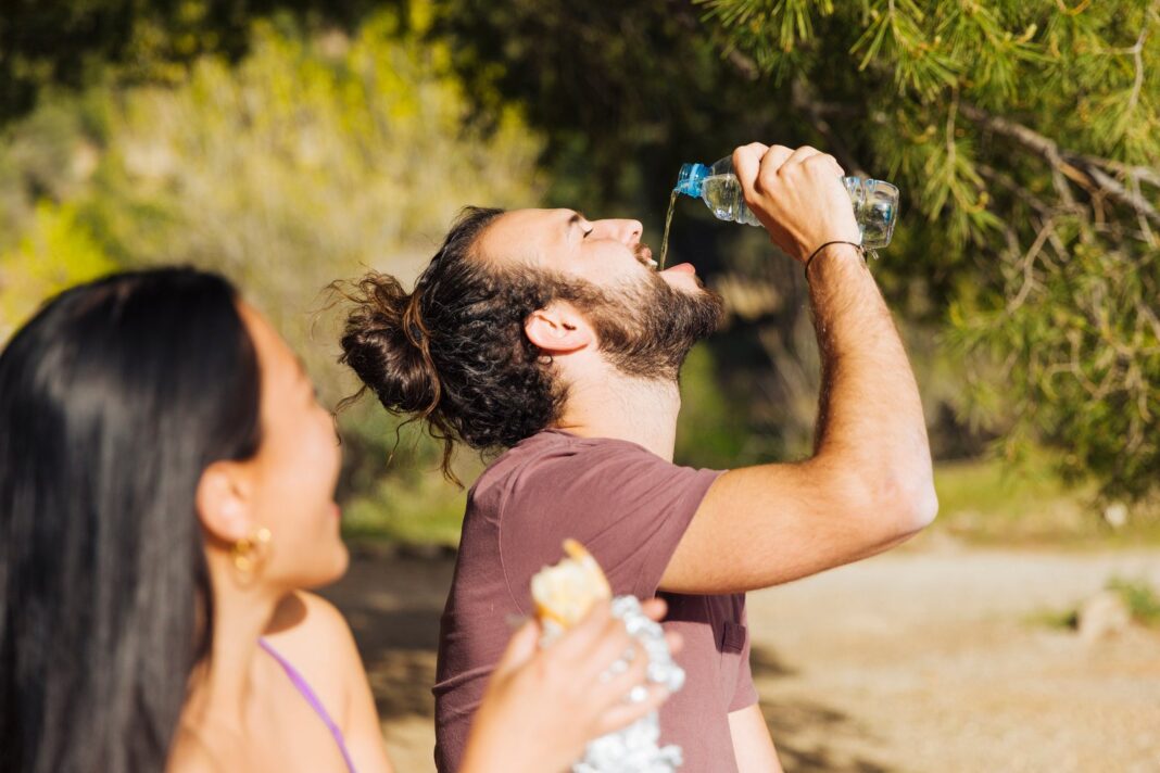 Persona bebiendo agua en un día caluroso de verano