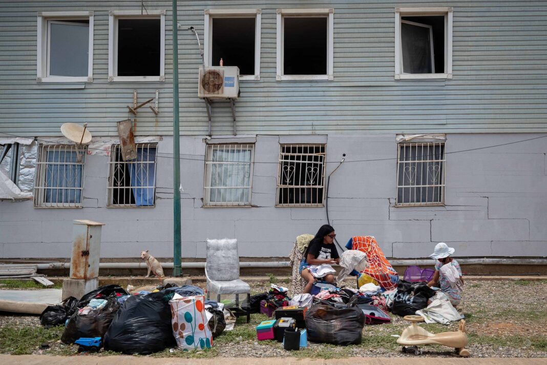 Campamento improvisado con carpas y sábanas en estacionamiento de farmacia en Catia La Mar, Venezuela