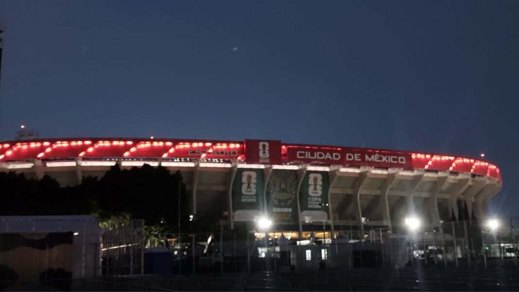 Estadio Ciudad de México iluminado con luces rojas y letrero del Mundial 2026 al atardecer