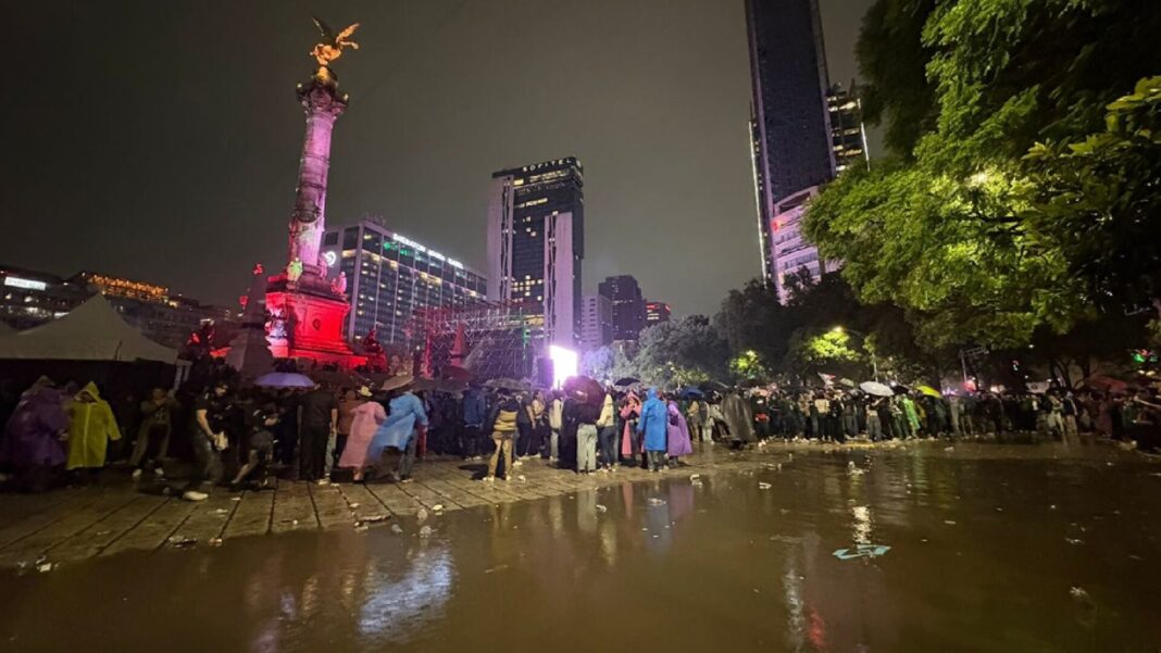 Aficionados mexicanos festejando en el Ángel de la Independencia durante la noche, con banderas y fuegos artificiales