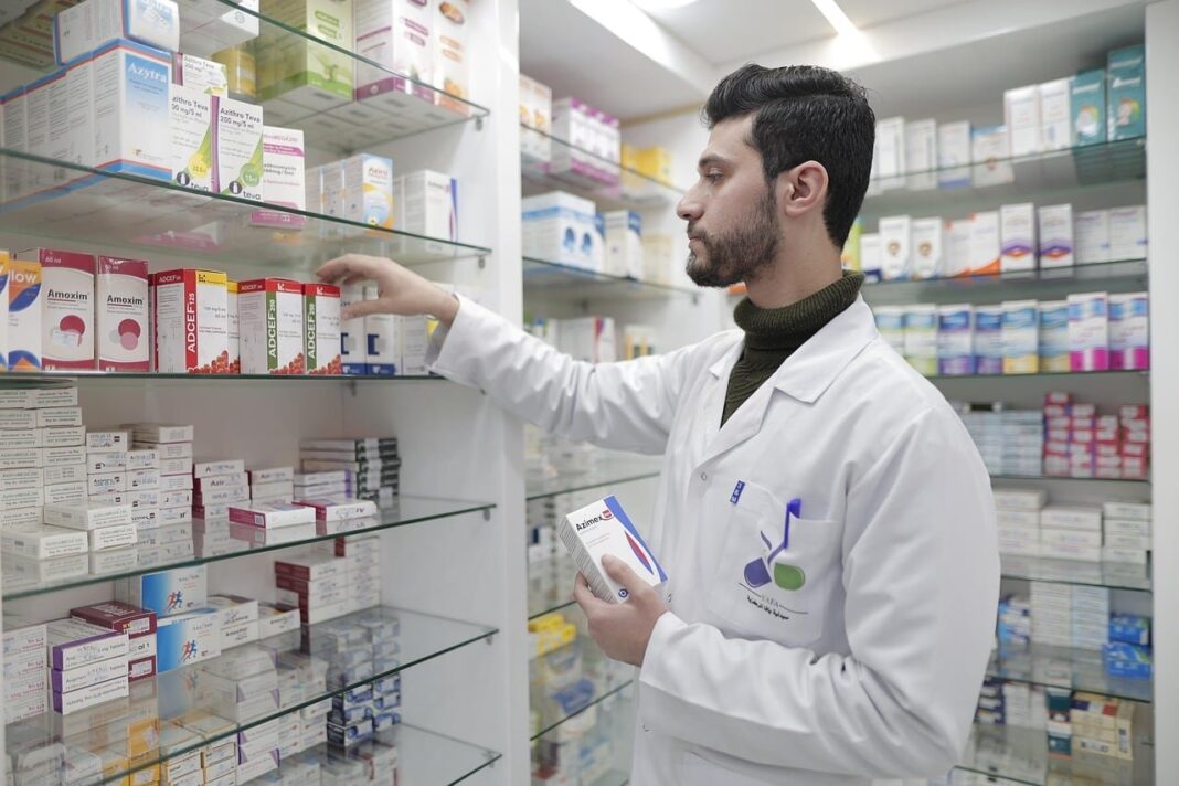 Persona retirando medicamentos en una farmacia con un dispositivo digital