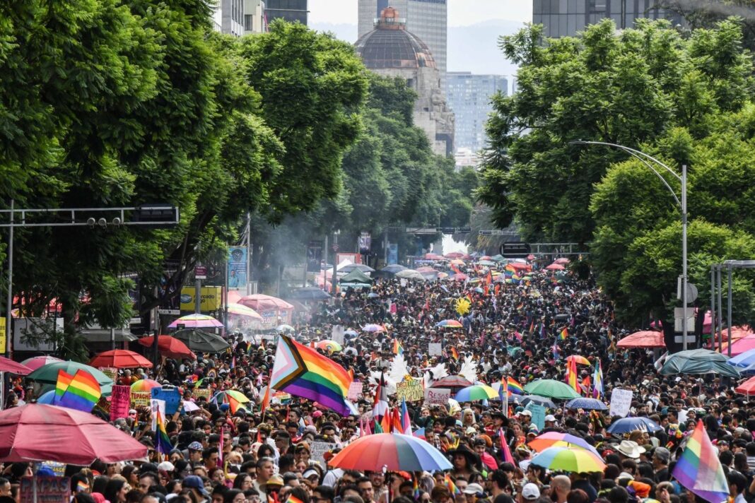 Personas con banderas arcoíris durante la Marcha del Orgullo en la Ciudad de México