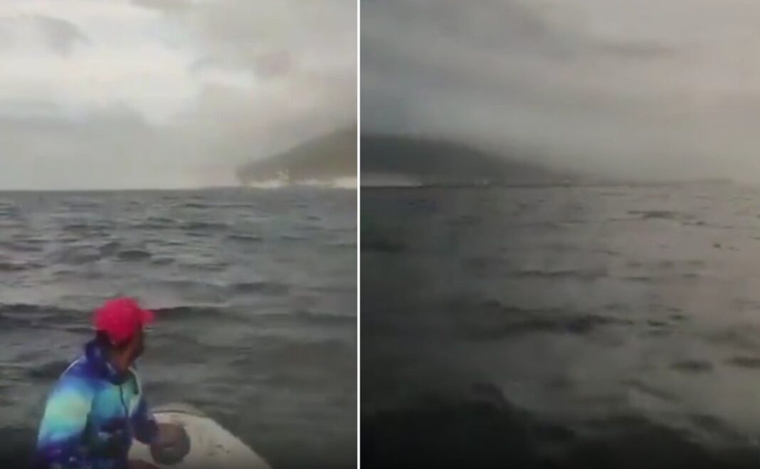 Pescadores en un bote observan el mar picado y la ciudad de La Guaira entre la bruma durante un terremoto