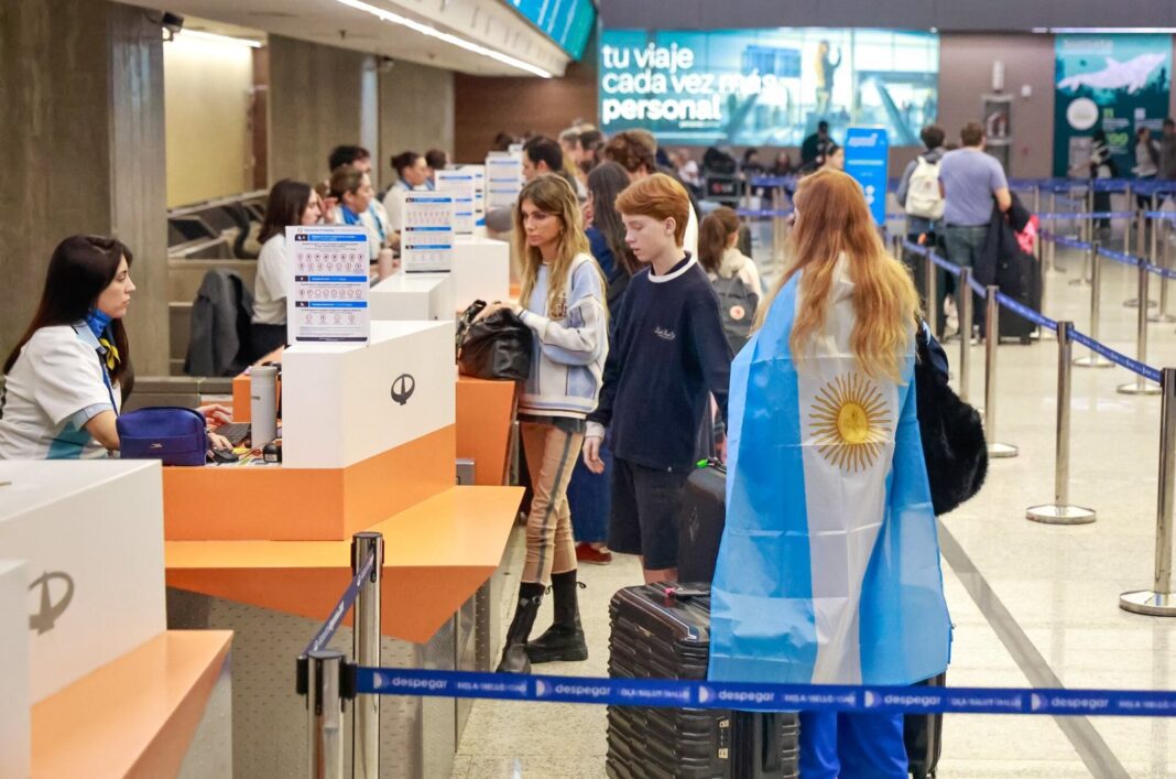 Pasajeros en el Aeropuerto de Ezeiza con remeras de la selección argentina antes de embarcar hacia Nueva York para la final del Mundial