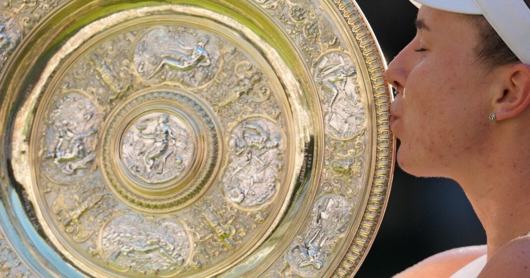 Linda Noskova sosteniendo el trofeo Venus Rosewater Dish en la cancha central de Wimbledon