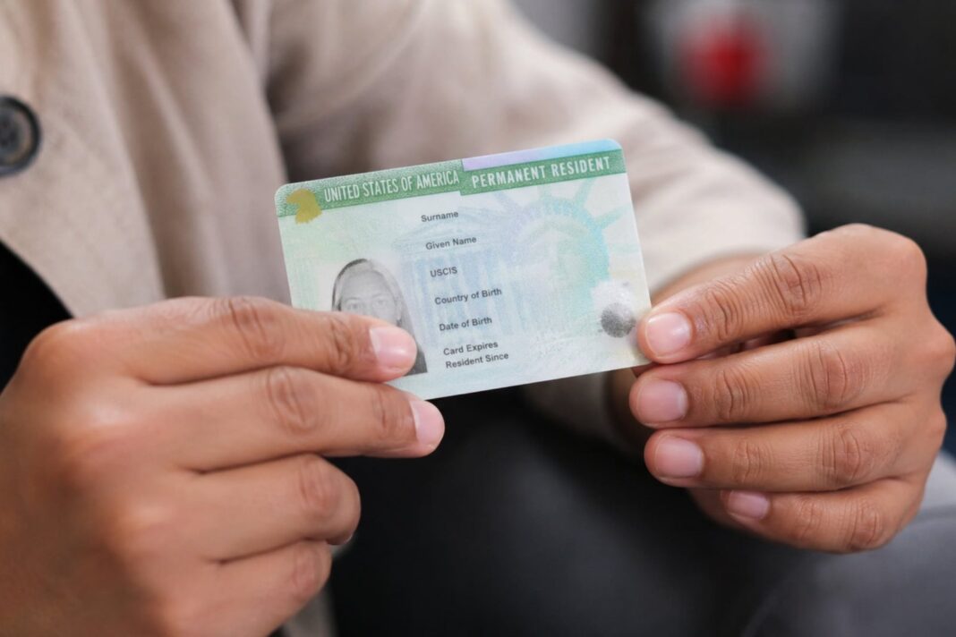 Documento de green card y bandera de Estados Unidos