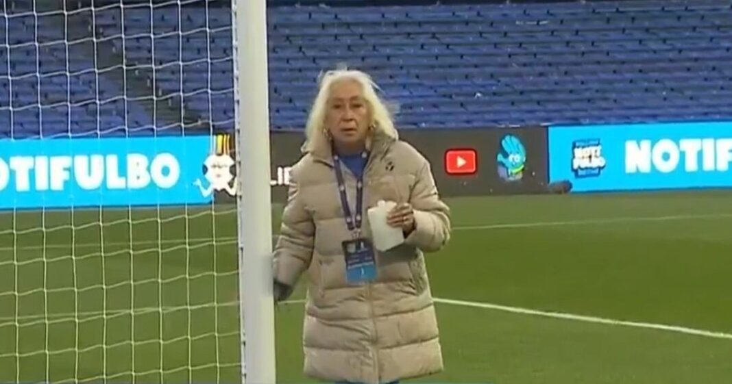 Mujer rociando con agua bendita uno de los arcos del estadio Gigante de Arroyito