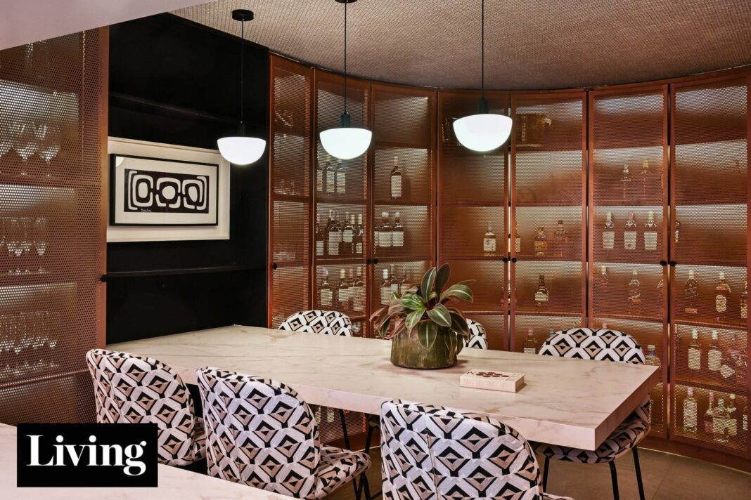 Living de un departamento en Montevideo renovado por Sofía Ruiz, con revestimiento de madera y obras de arte.