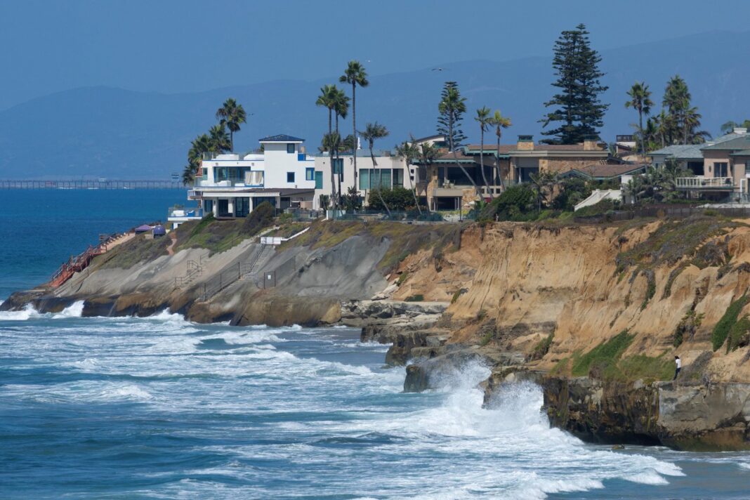 Vista aérea de la costa de California con oleaje elevado y nubes de tormenta
