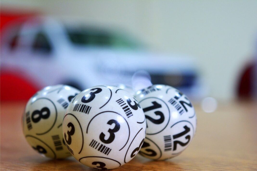 Sorteo de lotería con bolillas numeradas y pantalla mostrando números generados por inteligencia artificial