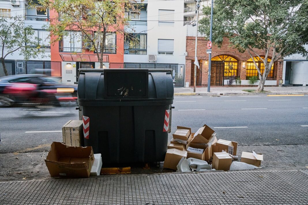 Vereda con bolsas de residuos y objetos en desuso esperando el servicio de recolección programada
