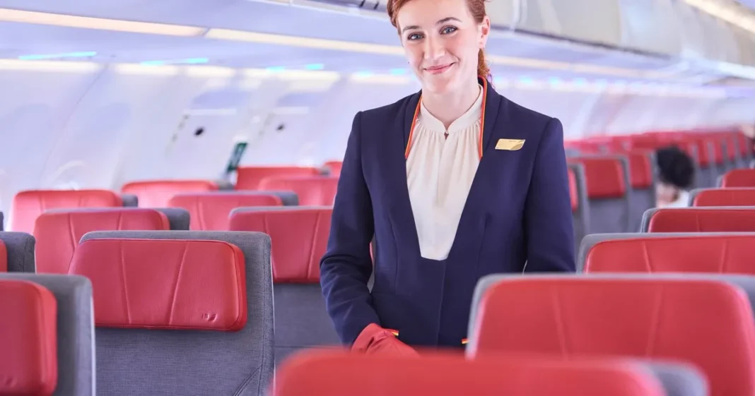 Azafata de Iberia en un avión, representando la evolución del trabajo de tripulante de cabina en los 80 años del primer vuelo comercial entre Madrid y Buenos Aires