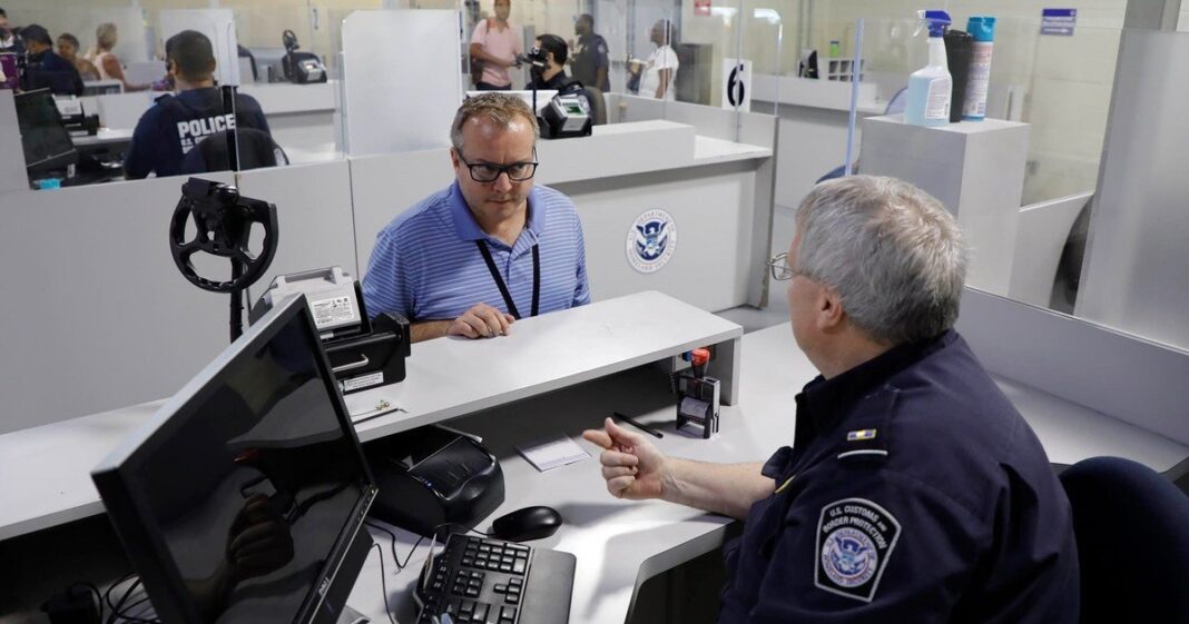 Oficial de la CBP revisando un teléfono celular en un puesto fronterizo