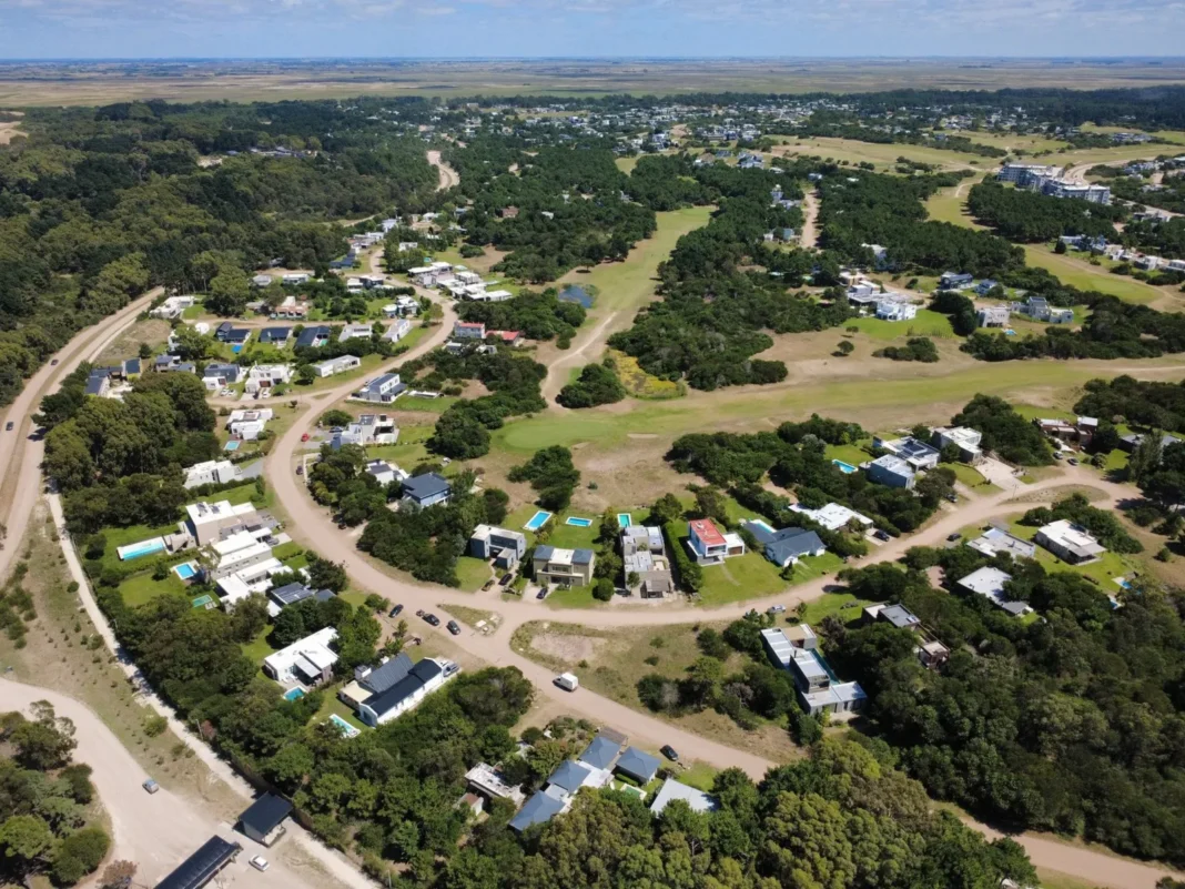 Vista aérea de un barrio cerrado con lotes vacíos y casas construidas en Costa Esmeralda