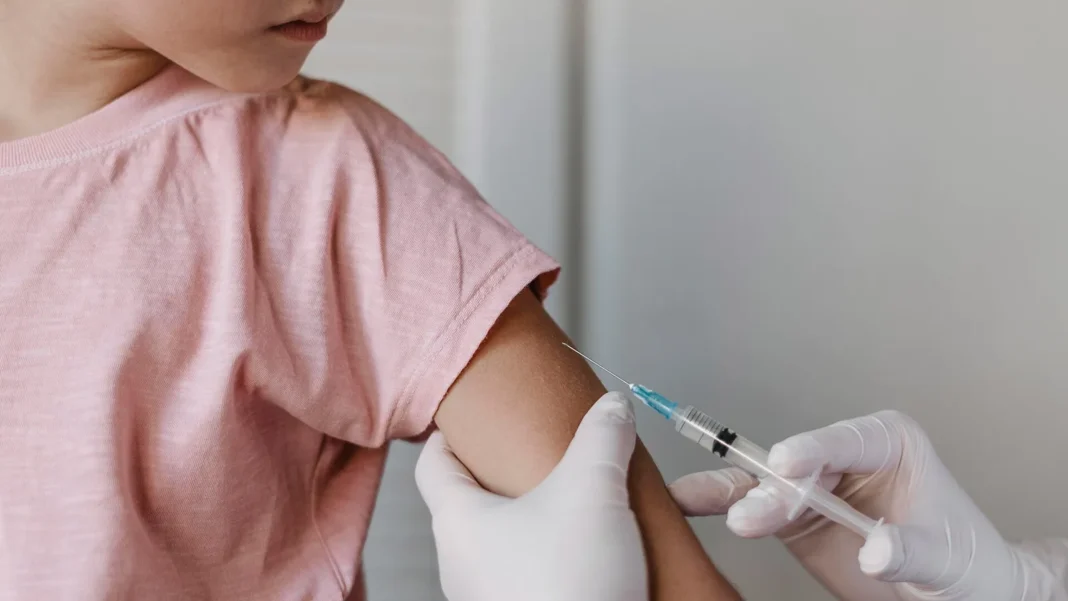 Profesional de la salud administra una vacuna contra la gripe a un niño en un centro médico de Estados Unidos
