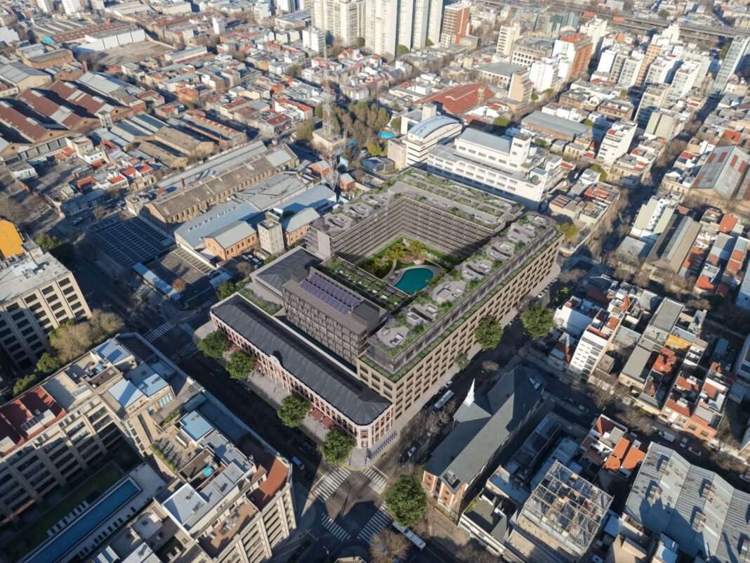 Fachada de ladrillo a la vista de la ex fábrica de Alpargatas en Barracas, con ventanas de medio punto y estructuras metálicas.